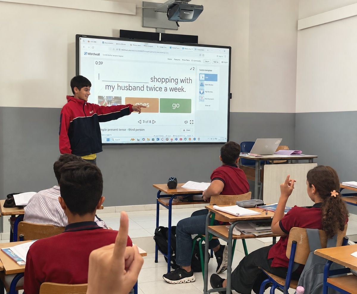 A student at the smart board leading a class activity at AMC